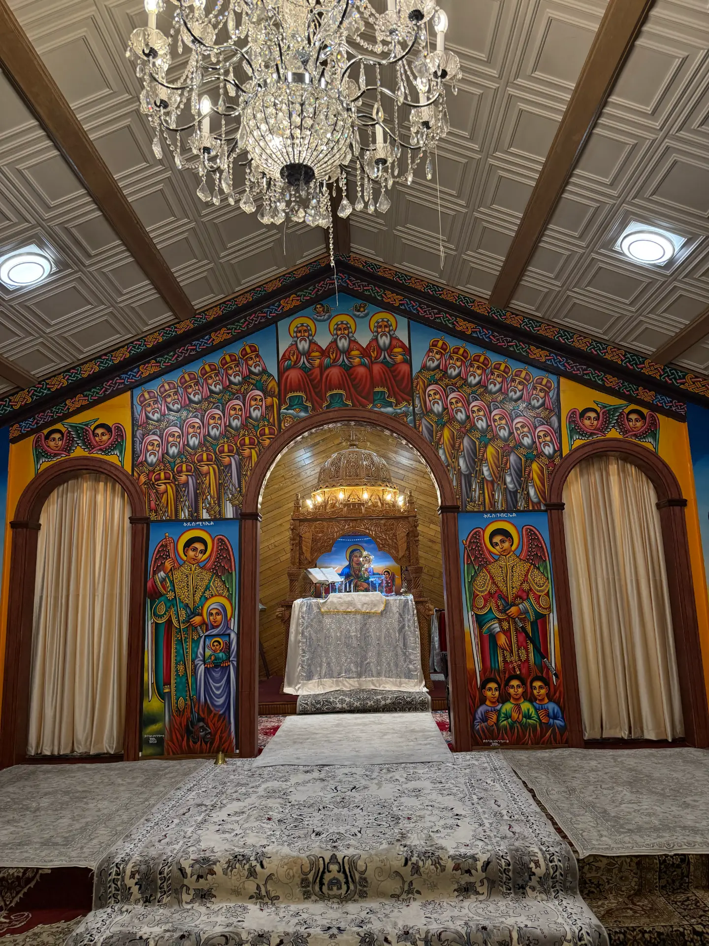 Sanctuary interior with iconography, altar, and chandelier